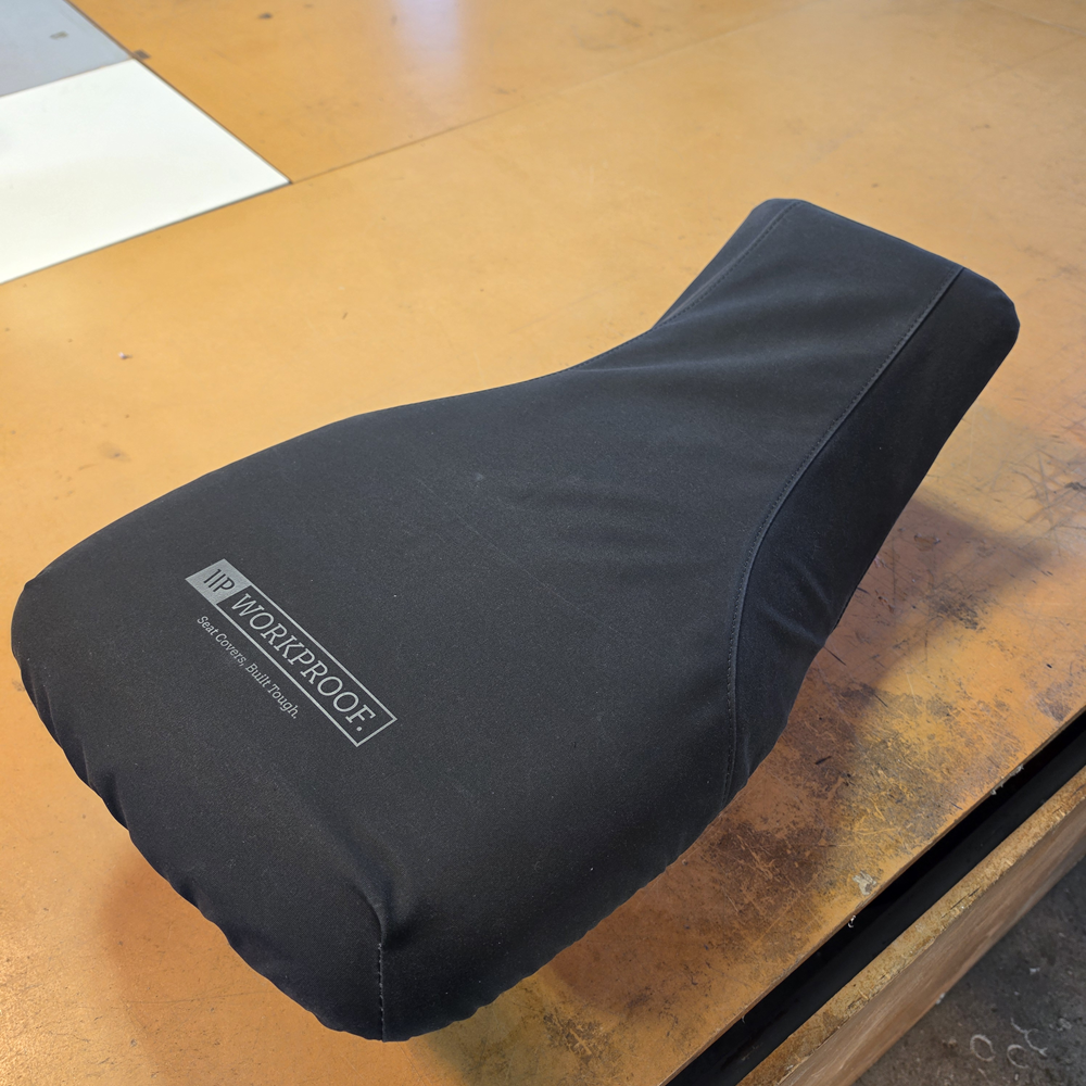 Black Workproof 12oz canvas seat cover fitted to a Polaris Sportsman 450/570 ATV, providing a snug fit and heavy-duty protection from mud, water, UV damage, and daily wear.