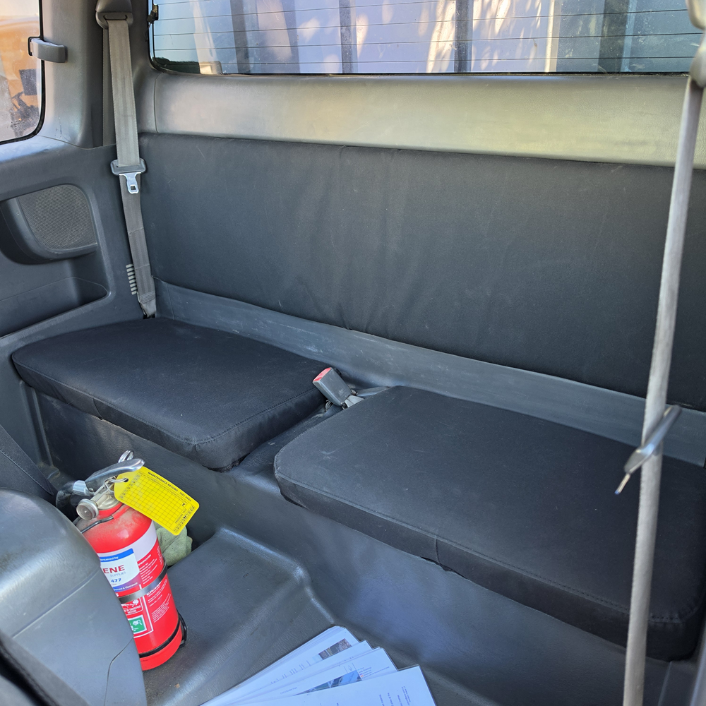 Toyota Hilux 2010–2015 Extra Cab rear seat fitted with WORKPROOF heavy-duty waterproof canvas seat covers in Black, designed for a factory-style fit and tough working conditions