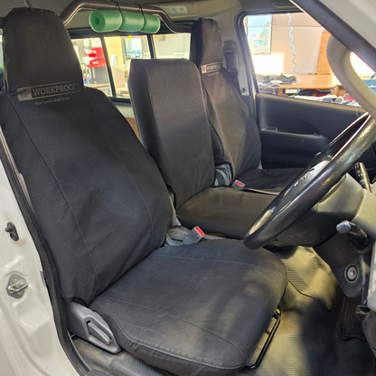 Toyota Hiace 2004 driver seat fitted with WORKPROOF heavy-duty waterproof canvas seat cover in black, factory-style fit for commercial vehicle protection