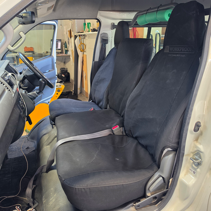 Toyota Hiace 2004 passenger view with black WORKPROOF waterproof canvas seat covers fitted, showing front seats and centre console in upright position with factory-style fit