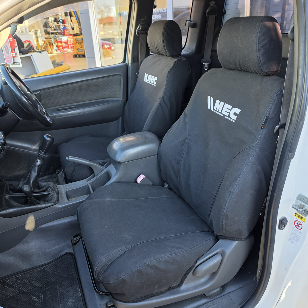 Toyota Hilux 2010–2015 front seats fitted with WORKPROOF heavy-duty waterproof canvas seat covers, factory-style fit designed for hard-working ute interiors