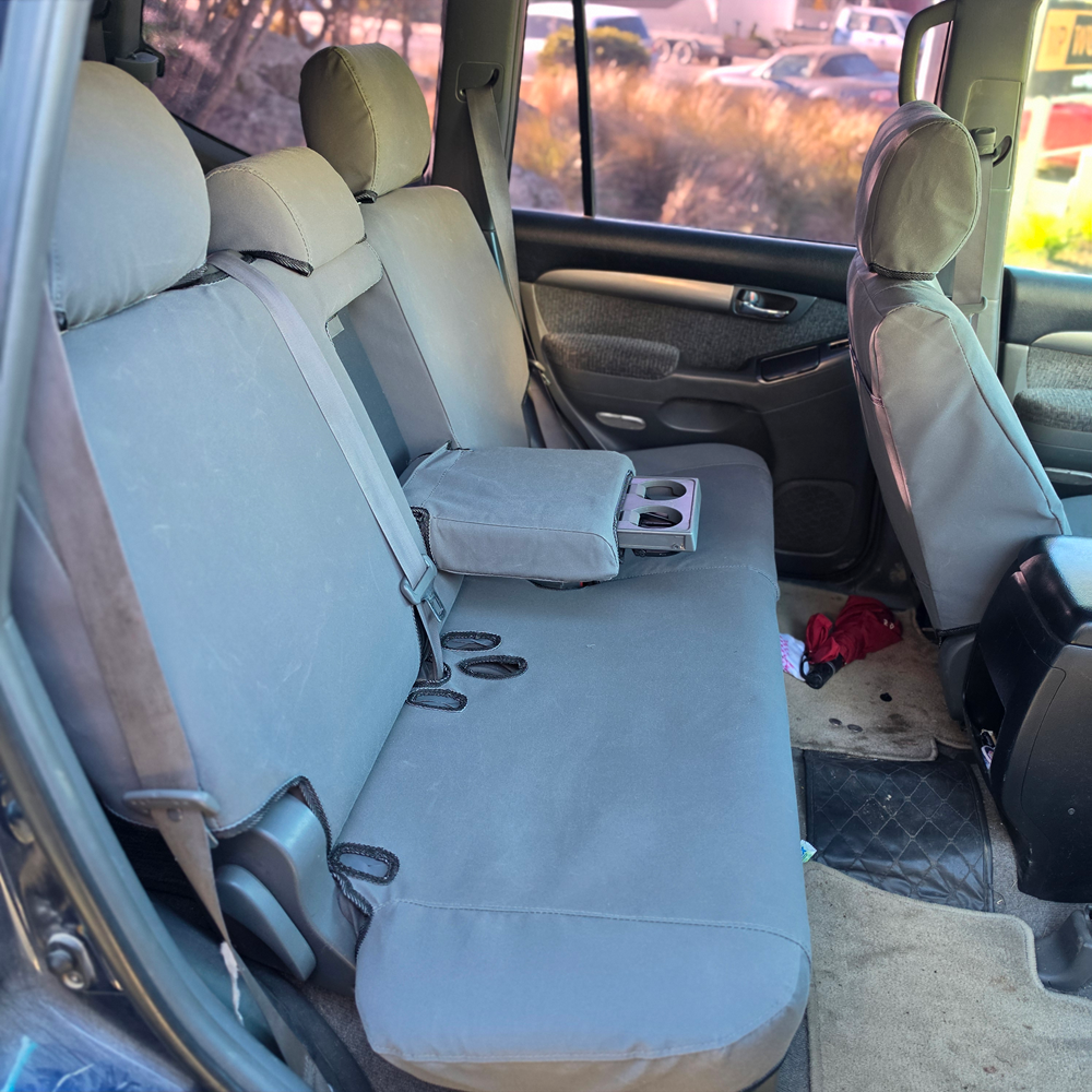 Toyota Land Cruiser Prado 2003–2009 charcoal canvas rear seat covers with center armrest and cupholder folded down, custom-fit Workproof seat covers.