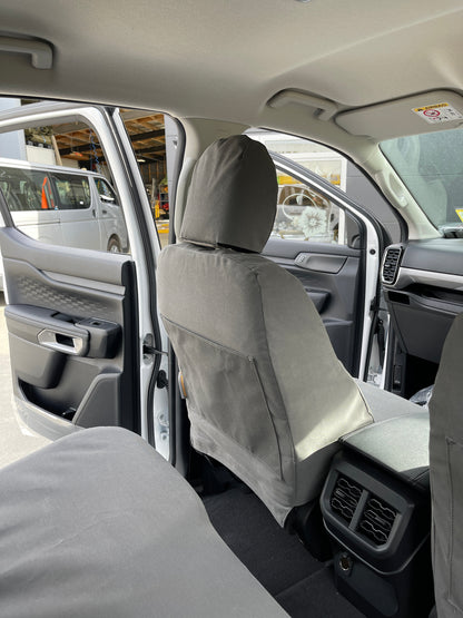 Rear cabin view of WORKPROOF heavy-duty front seat covers fitted to Ford Ranger showing durable waterproof protection and factory-style fit from the back seat perspective.